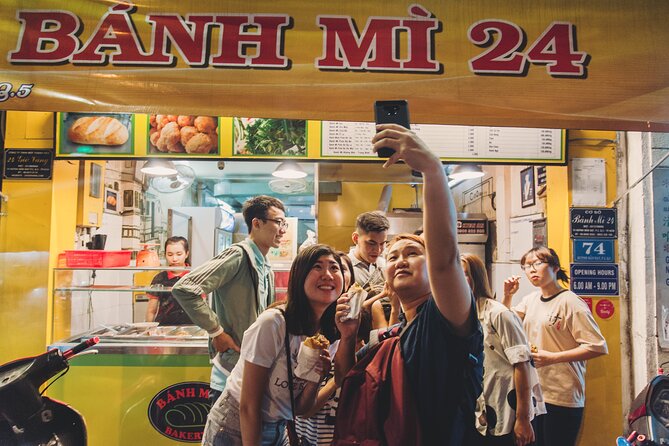 A lit banh mi counter on a Ho Chi Minh City street after dark
