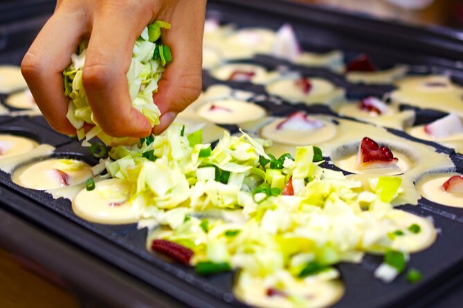 Takoyaki making experience ~Japan's popular street food~ - Filling the cooker with batter and octopus